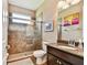 Bathroom featuring a glass shower, tiled walls, and granite countertop vanity with decorative artwork at 15135 Azra Dr, Odessa, FL 33556