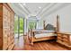 Bright bedroom with wooden floors, a large bed, sliding door, and trey ceiling at 15135 Azra Dr, Odessa, FL 33556