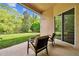 Covered patio area with a seating and view to the lush green backyard at 15135 Azra Dr, Odessa, FL 33556