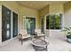Relaxing covered patio featuring a cozy seating area and access to a well manicured lawn at 15135 Azra Dr, Odessa, FL 33556