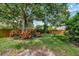 Backyard featuring vibrant plants, a large tree, and a cozy swing, perfect for relaxation at 1524 Essex N Dr, St Petersburg, FL 33710