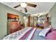 Spacious bedroom featuring an entertainment center, a ceiling fan, and two closets at 1524 Essex N Dr, St Petersburg, FL 33710
