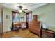Bedroom featuring hardwood floors, antique furniture, two windows and a ceiling fan at 1524 Essex N Dr, St Petersburg, FL 33710