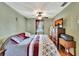 Bedroom with a ceiling fan, light green walls, and an entertainment center with a flatscreen television at 1524 Essex N Dr, St Petersburg, FL 33710