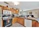 Cozy kitchen featuring wooden cabinets, granite countertops and a view of the dining area at 1524 Essex N Dr, St Petersburg, FL 33710