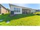 Well-maintained backyard with lush green lawn, exterior with AC, and covered patio at 15528 Corona Del Mar Dr, Wimauma, FL 33598