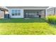 Well-maintained backyard featuring a lush green lawn and covered patio at 15528 Corona Del Mar Dr, Wimauma, FL 33598