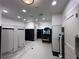 Community bathroom featuring white tile flooring, tiled half walls, stalls, and wooden bench at 15528 Corona Del Mar Dr, Wimauma, FL 33598