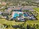 Aerial view of the luxurious community clubhouse featuring pools, cabanas, and manicured grounds at 15528 Corona Del Mar Dr, Wimauma, FL 33598