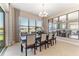 Elegant dining room with large windows, modern decor, and a view of the backyard at 15528 Corona Del Mar Dr, Wimauma, FL 33598
