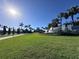 The Valencia community entrance is beautifully landscaped with lush green lawns and vibrant palm trees at 15528 Corona Del Mar Dr, Wimauma, FL 33598