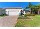 Charming single-Gathering home with a two-car garage, lush green lawn, and colorful flowerbeds enhancing curb appeal at 15528 Corona Del Mar Dr, Wimauma, FL 33598
