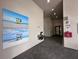 Hallway with beach-themed artwork, water fountains, and visible AED/restroom signs at 15528 Corona Del Mar Dr, Wimauma, FL 33598