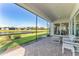 Screened in lanai with patio seating, tiled floor, and views of the lake at 15528 Corona Del Mar Dr, Wimauma, FL 33598