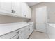 Laundry room featuring plenty of cabinet space, countertops, a sink, and tile flooring at 15528 Corona Del Mar Dr, Wimauma, FL 33598