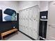 Locker room area showcasing lockers, a bench, weight scale, and abstract art piece at 15528 Corona Del Mar Dr, Wimauma, FL 33598