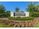 Attractive Valencia Del Sol community signage with manicured landscaping and a bright blue sky overhead at 15528 Corona Del Mar Dr, Wimauma, FL 33598