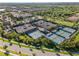 Aerial view of the Valencia Del Sol tennis courts and surrounding palm trees and community at 15528 Corona Del Mar Dr, Wimauma, FL 33598