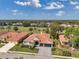 Aerial view of landscaped home, featuring a tile roof, manicured lawn, and three-car garage at 1617 El Pardo Dr, Trinity, FL 34655