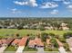 This aerial view captures a neighborhood of tile-roofed homes with a golf course as a backdrop at 1617 El Pardo Dr, Trinity, FL 34655