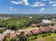 Scenic aerial view of the homes with terracotta roofs near a serene lake and lush greenery at 1617 El Pardo Dr, Trinity, FL 34655