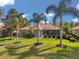 Well-maintained backyard featuring lush green grass, palm trees, and screened in patio at 1617 El Pardo Dr, Trinity, FL 34655