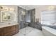 Spa-like bathroom features a glass shower, freestanding tub, and a vanity with an illuminated mirror and ample storage at 1617 El Pardo Dr, Trinity, FL 34655