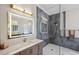 Modern bathroom features a glass-enclosed shower with marble-look tile and a vanity with an illuminated mirror at 1617 El Pardo Dr, Trinity, FL 34655