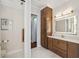 Well-lit bathroom featuring a vanity with ample storage, marble floors, and toilet behind a half wall at 1617 El Pardo Dr, Trinity, FL 34655