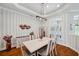 Dining area featuring hardwood floors, striped wall decor, modern chandelier, and white wood table at 1617 El Pardo Dr, Trinity, FL 34655