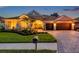 Stunning single-story home featuring lush landscaping and a paver driveway leading to a spacious three-car garage at 1617 El Pardo Dr, Trinity, FL 34655