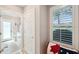 Bright hallway features plantation shutters on the window and connects to the bathroom at 1617 El Pardo Dr, Trinity, FL 34655