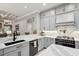 Modern kitchen with sleek gray cabinets, stainless steel appliances, and a stylish tile backsplash at 1617 El Pardo Dr, Trinity, FL 34655