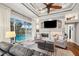 Living room with a fireplace, pool view, tray ceiling, ceiling fan, and comfortable seating at 1617 El Pardo Dr, Trinity, FL 34655