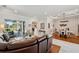 Open living space featuring hardwood floors, dining area, brown leather sofa, and view of the backyard at 1617 El Pardo Dr, Trinity, FL 34655