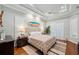 Spacious main bedroom features a tray ceiling, plantation shutters, and a king-size bed with decorative surfboard art at 1617 El Pardo Dr, Trinity, FL 34655