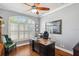 Home office boasts a large window, hardwood floors, a wooden desk, and a ceiling fan at 1617 El Pardo Dr, Trinity, FL 34655