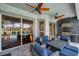 This outdoor kitchen features stone floors, fan, nice grill, and comfortable seating with a view of the pool at 1617 El Pardo Dr, Trinity, FL 34655