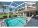 Private pool area features ample seating, mature tropical landscaping and screened-in entertainment space at 1617 El Pardo Dr, Trinity, FL 34655