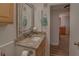 A bathroom with granite counters and a decorative mirror at 1710 Belleair Forest Dr # A, Belleair, FL 33756