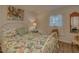 Bright bedroom featuring a floral-themed bed, vintage dresser and accents and hardwood floors at 1710 Belleair Forest Dr # A, Belleair, FL 33756