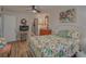 Bright bedroom featuring a floral-themed bed, TV, closet, and hardwood floors at 1710 Belleair Forest Dr # A, Belleair, FL 33756
