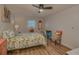 Airy bedroom featuring a floral-themed bed, a ceiling fan, and hardwood floors at 1710 Belleair Forest Dr # A, Belleair, FL 33756