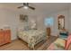 Cozy bedroom with a floral-themed bed, ceiling fan and vintage-style furnishings at 1710 Belleair Forest Dr # A, Belleair, FL 33756