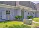 Exterior view of townhome featuring well-manicured lawn and green front door at 1710 Belleair Forest Dr # A, Belleair, FL 33756