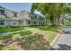 Well-maintained townhouses with green lawns, lush trees, and sidewalks at 1710 Belleair Forest Dr # A, Belleair, FL 33756