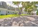 Exterior view of townhomes with mature trees and landscaping at 1710 Belleair Forest Dr # A, Belleair, FL 33756