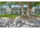 Charming townhouse with dormer windows, surrounded by mature trees and lush landscaping at 1710 Belleair Forest Dr # A, Belleair, FL 33756