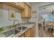 Open kitchen featuring double stainless steel sinks, wood cabinets and granite countertops at 1710 Belleair Forest Dr # A, Belleair, FL 33756