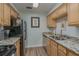 Well-lit kitchen featuring wood cabinets, granite counters, and stainless steel appliances at 1710 Belleair Forest Dr # A, Belleair, FL 33756